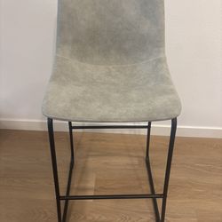 Gray upholstered bar stool with metal legs.