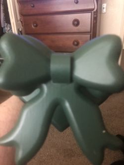 Dark green wooden quilt holder base is heart shape W/bow in front hangs on wall