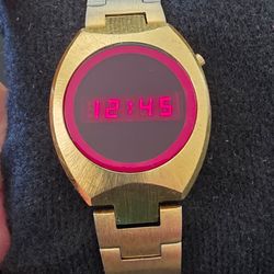 The VTG Compu Chron Hughes Aircraft Co. Module Red LED Digital 25mm Watch is a vintage wristwatch from the 1970s, featuring a unique LED display and a