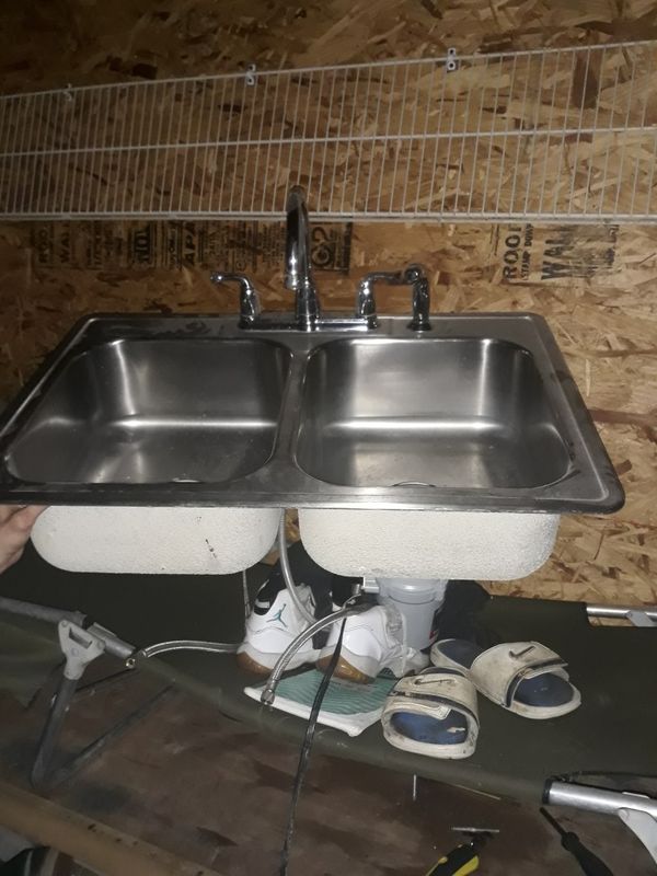 Double stainless steel sink with faucet and garbage disposal attached