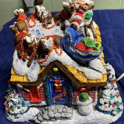 Christmas House Decorated With Santa And Reindeer On The Roof