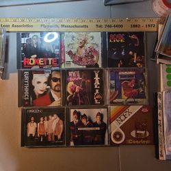 Collection of nine CDs, including albums by Roxette, Pink, AC/DC, Cyndi Lauper, Billy Idol, INXS, Maroon 5, and NOFX.