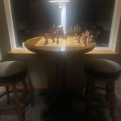 Tall Chairs And Table With Chess Board On It