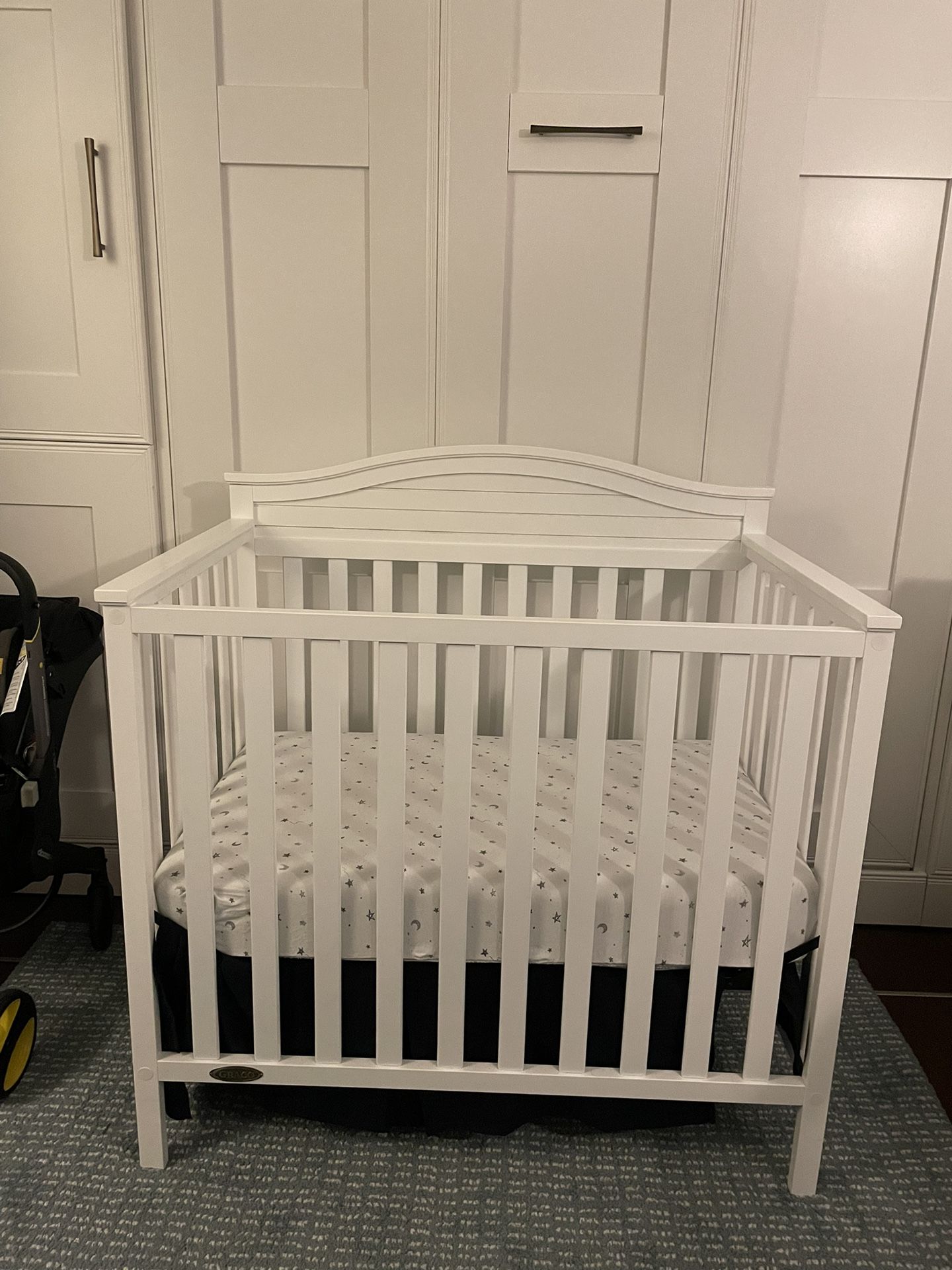 Mini Crib w/ nice coil mattress & navy bed skirt. for Sale in Seattle