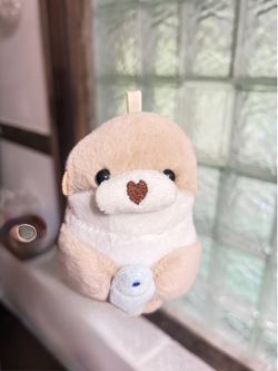 Brown otter plush keychain with blue fish