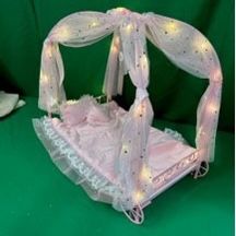 New.  Firm, Badger Basket Royal Carriage Metal Doll Bed with Canopy, Bedding and LED Lights - Pink/White/Stars