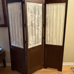Vintage brown wood folding room divider with white lace curtain panels