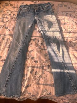 Miss Me brand blue jeans, featuring a medium wash and bootcut leg