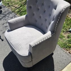 Gray fabric chair with grommit accents.