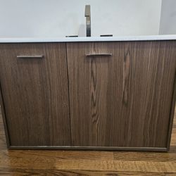 Wall mounted Kohler walnut flax cabinet with Enameled cast iron vanity top with rectangular sink