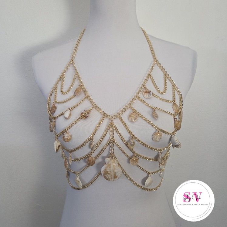 Gold chain body jewelry adorned with shell decor.