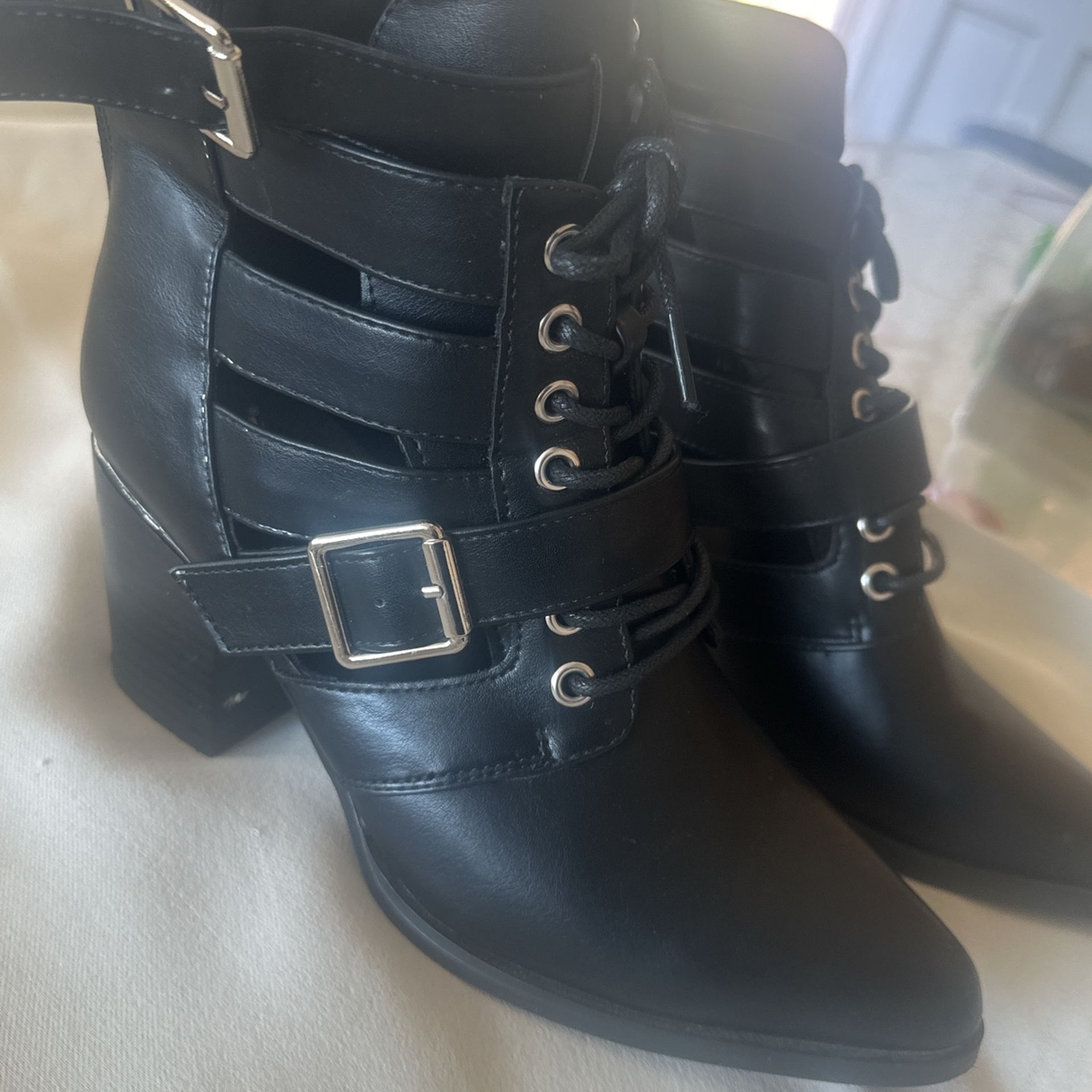 black heeled boot with buckles.