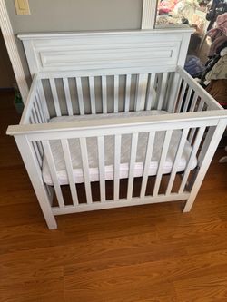 Mini crib with mattress.