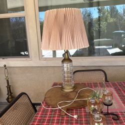 vintage-style table lamp features a crystal column base with brass accents and a pleated fabric shade