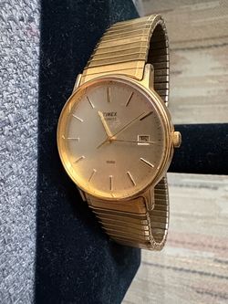 This is a classic vintage 1980s–1990s Timex Quartz men’s dress watch with a date display and expansion bracelet.