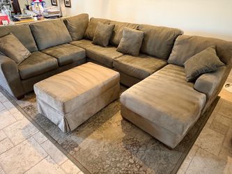 Green upholdered sectional sofa with chaise lounger and ottoman