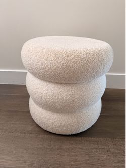 White faux fur ottoman with black lining and storage