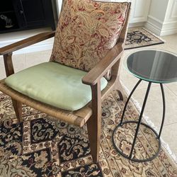 Wood And Wicker Chair With Cushions And Round Glass Side Table