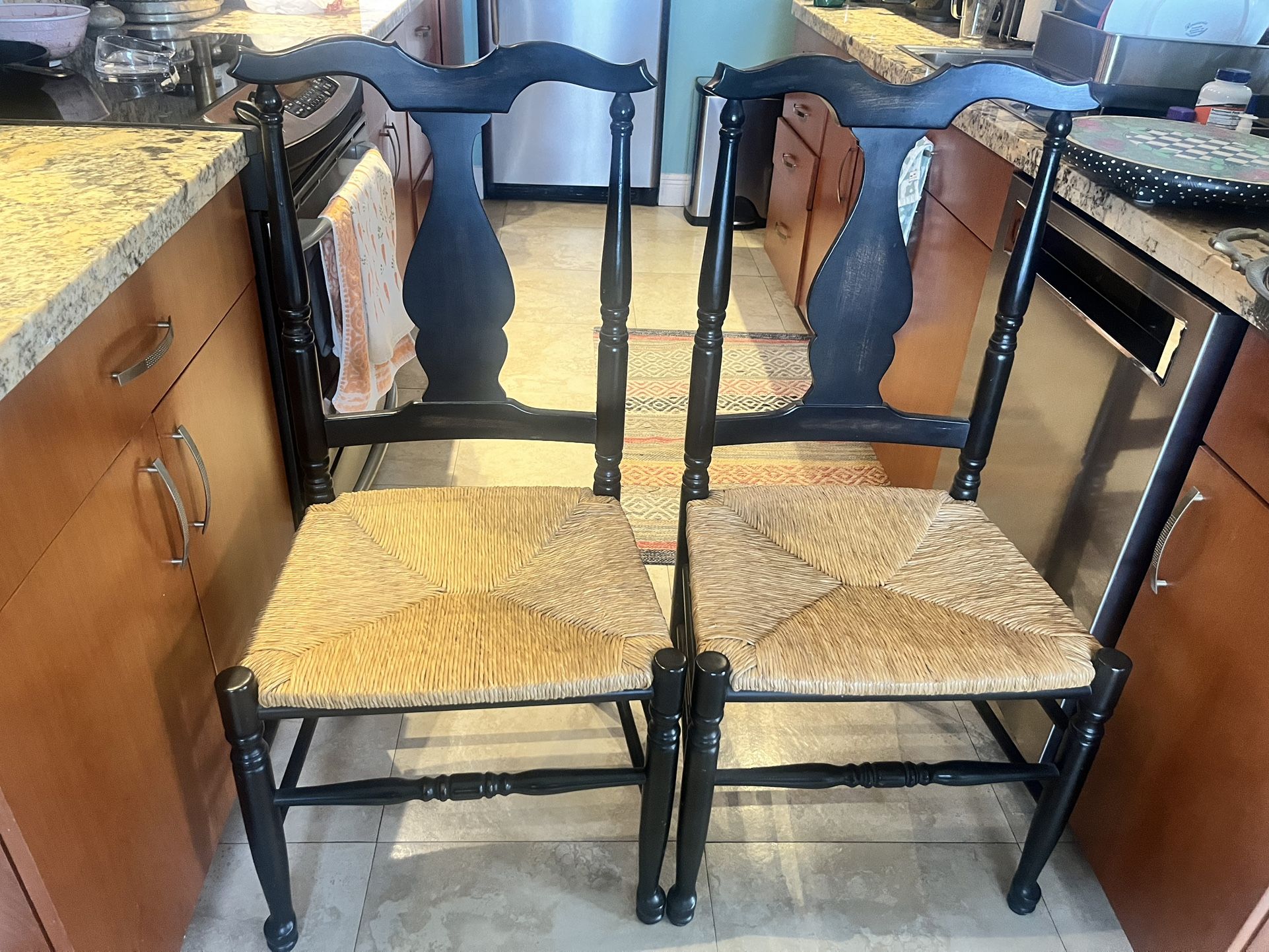 Pottery Barn black pedestal bistro table with two rush-seat chairs; solid, stylish, minor cosmetic wear on tabletop, priced to sell.