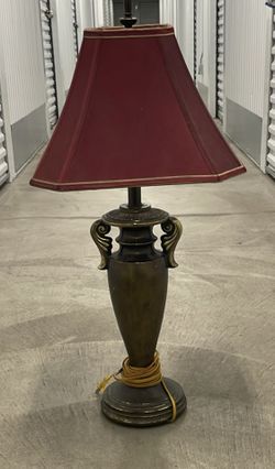bronze and burgundy table lamp with a leaf design.