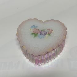 Fenton heart-shaped trinket box made of iridescent and white satin glass. It has a ribbed base and a hand-painted floral design on the lid.  1950’s Le