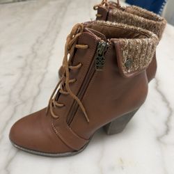 This is a pair of Daisy Fuentes Stormi brown faux leather combat ankle boots with a knit cuff and chunky block heel. Size.7 