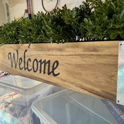 Welcome Sign And Fake Plant