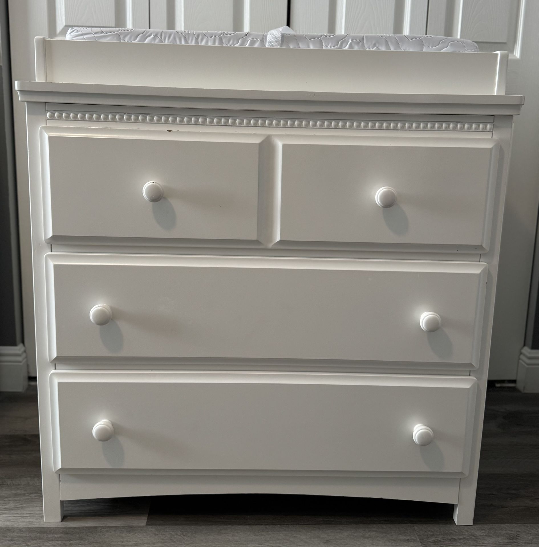 “Delta” Children 3 Drawer Dresser with Changing Top along with a “Colgate” Contour Changing Pad