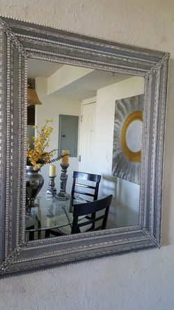 Este es un lindo espejo decorado completamente en todo sus vorde con un fino metal plateado es unico hermoso