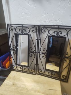 A pair of wrought iron scrollwork mirrors