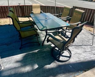 Outdoor patio furniture with 6 chairs included and beige/ tan umbrella
