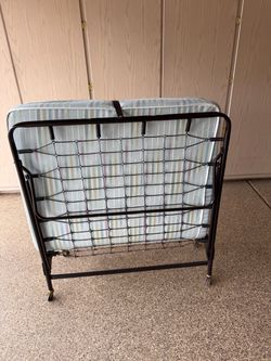 Twin cot on wheels with cover. Like new condition