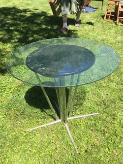 Circular glass table with aluminum legs. 36” in diameter & 34” high