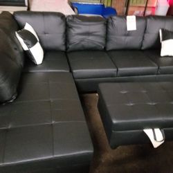 Contemporary black faux leather sectional with a matching storage ottoman