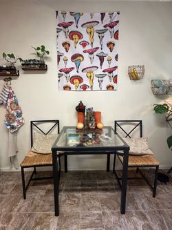 Glass dining table with two woven chairs