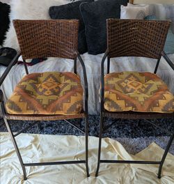 Set of two crate& barrel woven rattan and metal counter stools featuring pattern cushions.