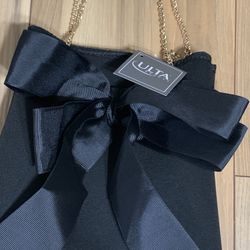 Ulta black bow bag with gold chain straps and a bow on the front