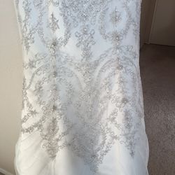 Oleg Cassini White bead embroidered wedding dress Size 10 Ivory mermaid style with a sweetheart neckline

Condition is used with a couple small tears 