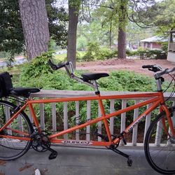 Orange Two seat bike with storage bag on the back