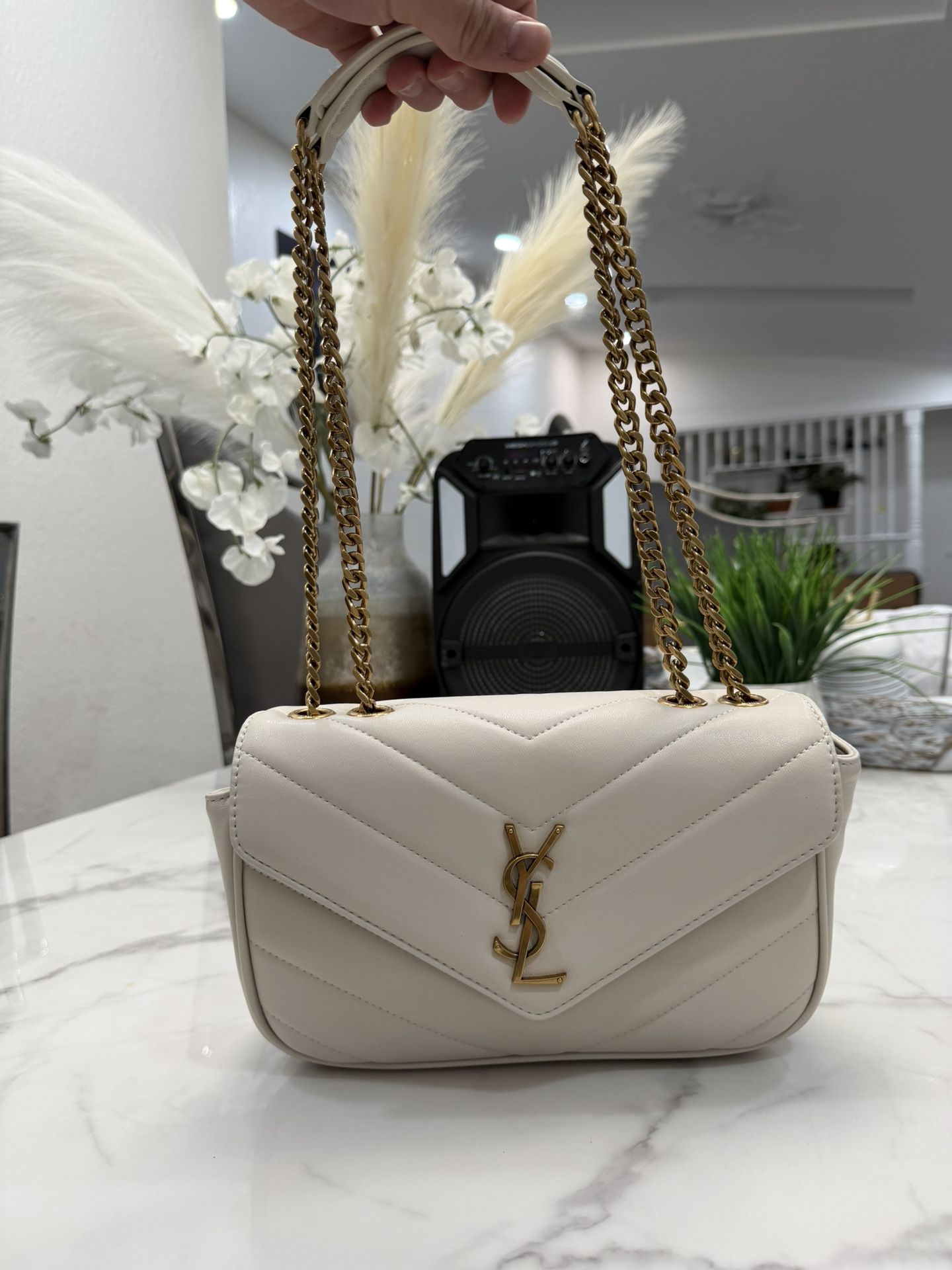 Saint Laurent Loulou bag in white quilted leather with a gold-toned YSL logo and chain strap. 