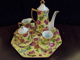 Baum Brothers Formalities miniature porcelain tea set, typically featuring a yellow background with pink chintz flowers.
