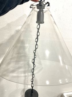 Modern pendant light with a cone-shaped clear glass shade.