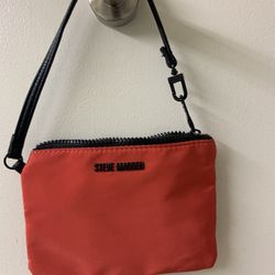 Red  clutch (cosmetic bag or purse bracelet) Steve Madden with a black strap.