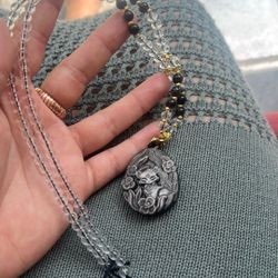 Nine-Tailed Fox pendant necklace featuring a carved obsidian stone and clear crystal beads. The Nine-Tailed Fox is a symbol of wisdom, charm, and prot