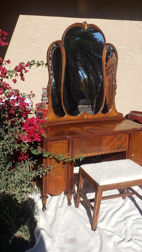 Vintage vanity with a mirror and stool.