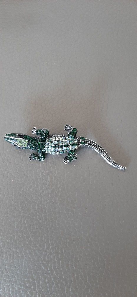 Alligator-shaped brooch  with multicolored stones.