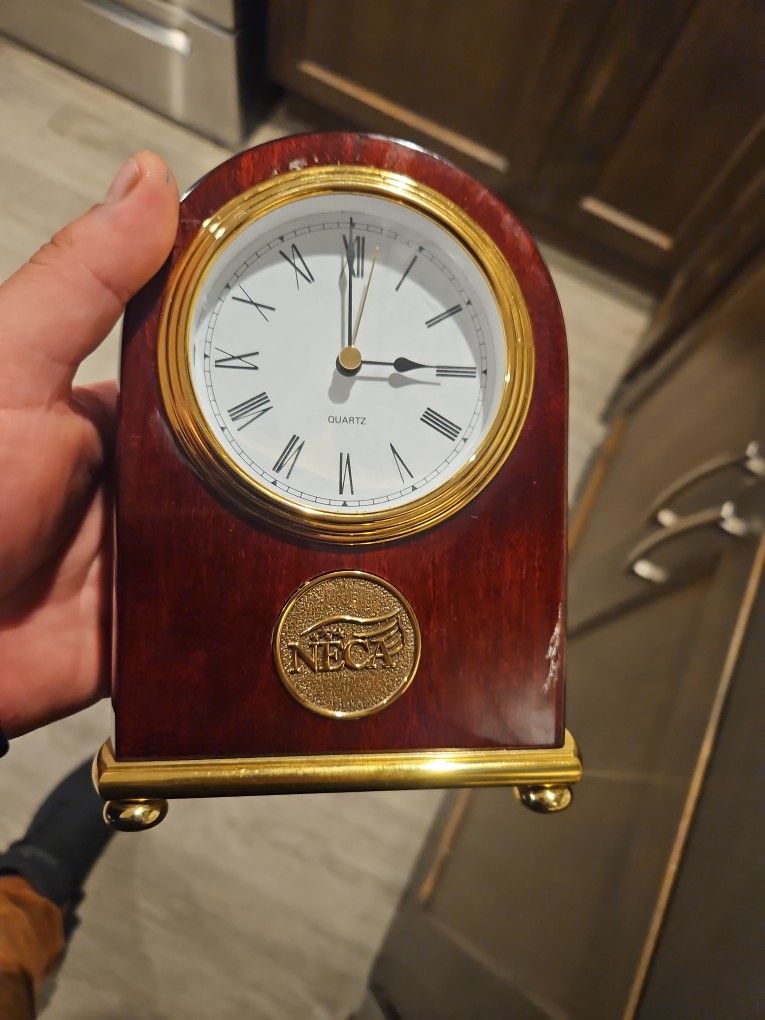 A polished wooden commemorative clock with a brass plaque commemorating NECA's 100th anniversary (1(contact info removed)).