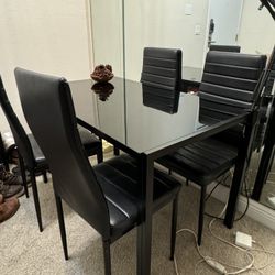 a table with 4 black chairs