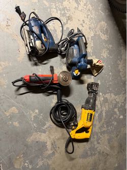 A selection of used power tools, including: a reciprocating saw, sander, jigsaw, and router.