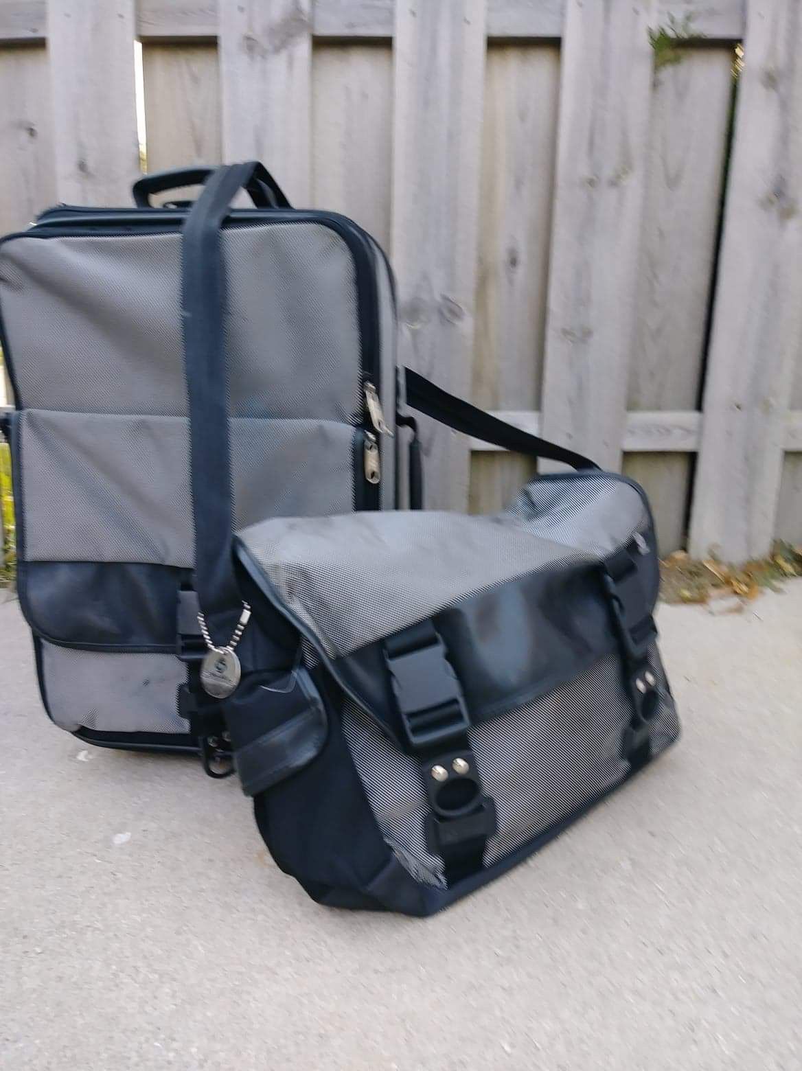 Samsonite gray/ platinum and black wheel handled carry on bag and over-the-shoulder messenger bag.